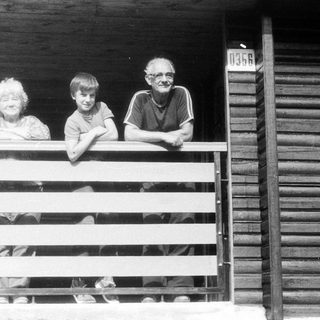 Family posing on wooden porch steps.
