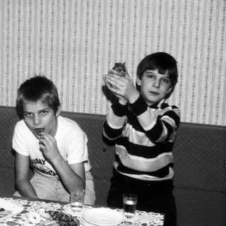Family gathering with cake, smiling indoors.