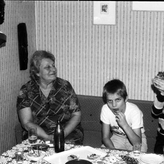 Family gathering with cake, smiling indoors.