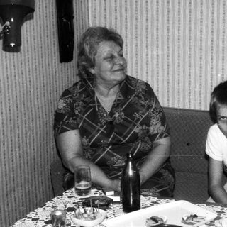 Family gathering with cake, smiling indoors.