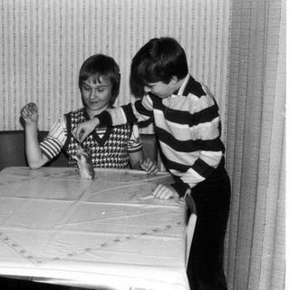 Two children playing board game indoors.