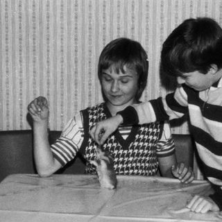 Two children playing board game indoors.