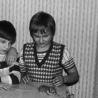 Three children sitting together at a table indoors.