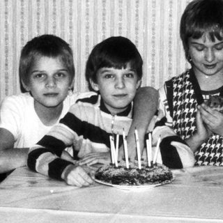 Three children posing with birthday cake.