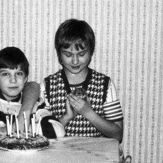 Three children posing with birthday cake.