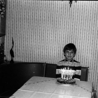 Young boy blowing out birthday candles on cake.