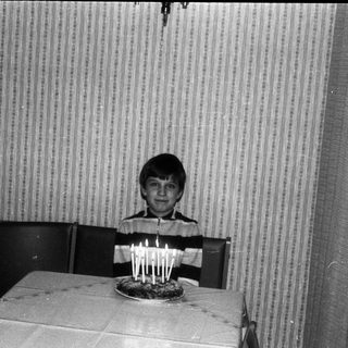 Young boy blowing out birthday candles on cake.