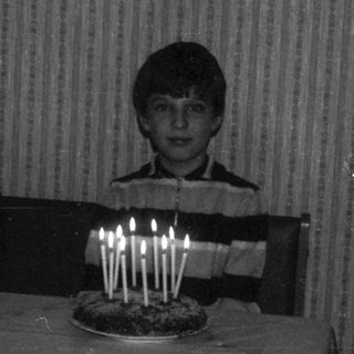 Child blowing out birthday candles on cake.