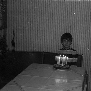 Child blowing out birthday candles on cake.