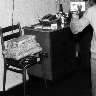 Young boy holding Christmas gift card indoors.
