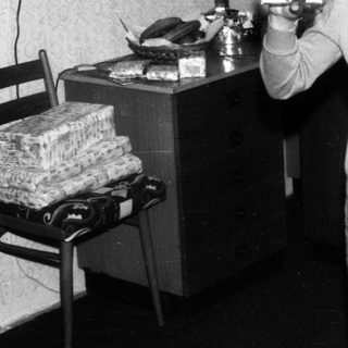 Young boy holding Christmas gift card indoors.