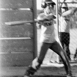 Baseball player swinging bat during practice.