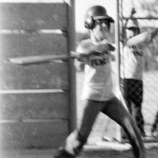 Baseball player swinging bat during practice.
