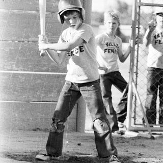 Two boys playing tee-ball in 1970s-style attire.