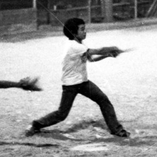 Children playing baseball at night.