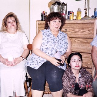 Group of four people indoors, seated casually.