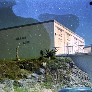 "Airman's Club building on coastal cliff."