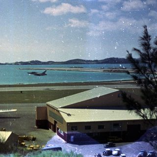 Airport runway by coastal waterfront with planes.