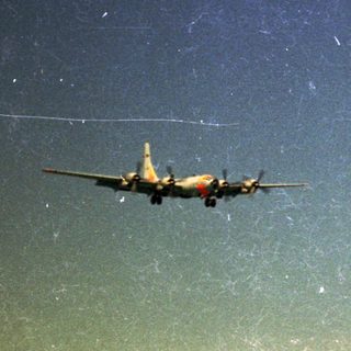 Airplane flying at night under starry sky.
