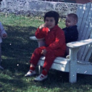 Three children and a dog in backyard.