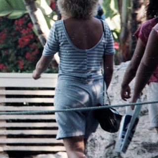 People walking outdoors near a waterfront area.