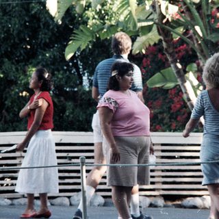 People walking outdoors near a waterfront area.