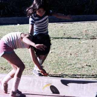 Two children playing frisbee outdoors.