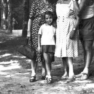 Family posing outdoors in wooded area.