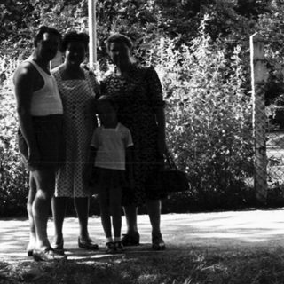 Family posing under "Te Em Favor Espresso" sign.
