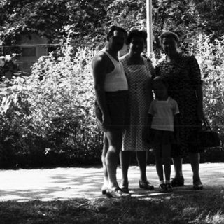 Family posing under "Te Em Favor Espresso" sign.