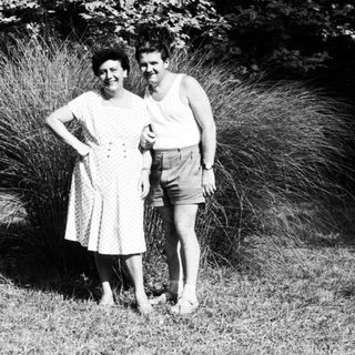 Two people posing together outdoors in summer attire.