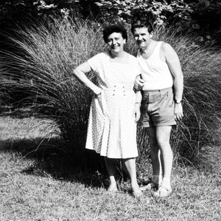 Two people posing together outdoors in summer attire.
