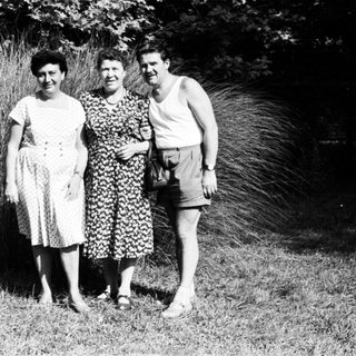 Three people posing outdoors in summer attire, 1950s-60s.
