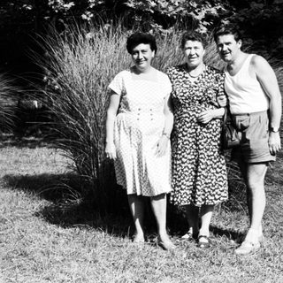 Three people posing outdoors in summer attire, 1950s-60s.