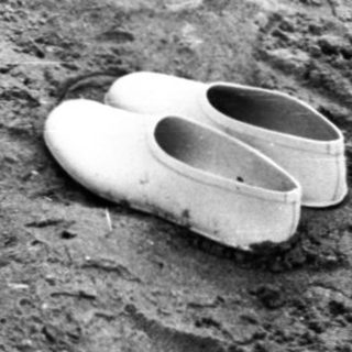 Child digging in muddy ground with tools.