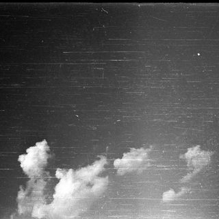 Dark sky with scattered, fluffy clouds.