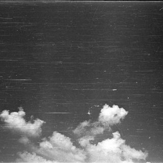 Dark sky with streaks and fluffy clouds.