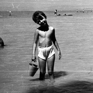 Shallow water scene with children playing near shore.