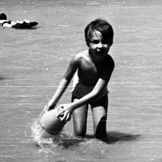 Shallow water scene with children playing near dock.