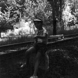 Person riding bicycle near railway tracks in rural area.