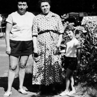 Family walking outdoors in vintage clothing.