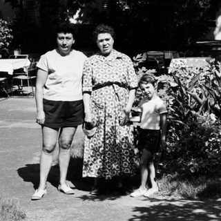 Family walking outdoors in vintage clothing.