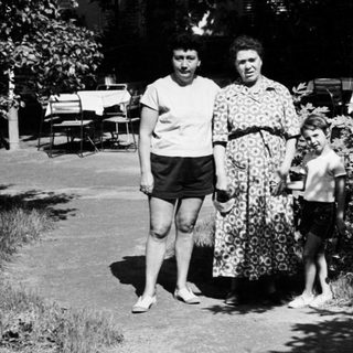Family walking outdoors in vintage clothing.
