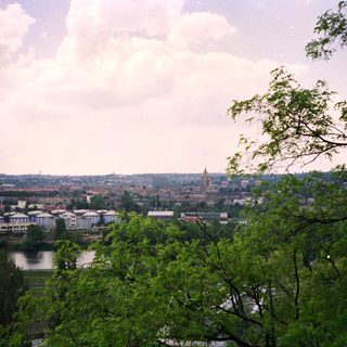 Panoramic view of city with river and greenery.