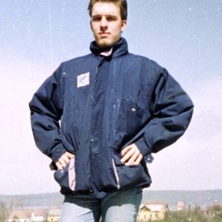 Man standing on rooftop ruins with scenic view.