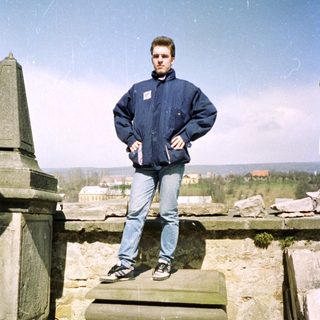 Man standing on rooftop ruins with scenic view.