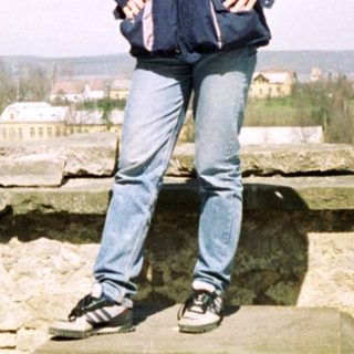 Man standing on rooftop ruins with scenic view.
