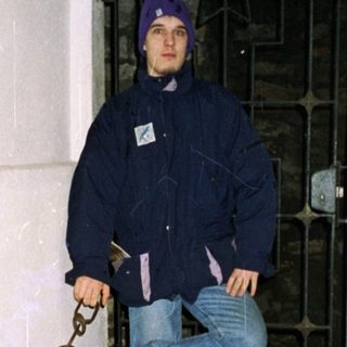 Person chained to wall in confined space.