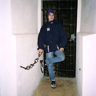 Person chained to wall in confined space.