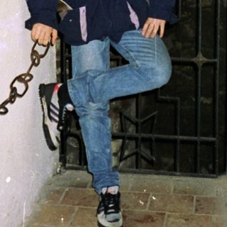 Person chained to wall in confined space.